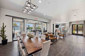 a dining room with a long wooden table and chairs